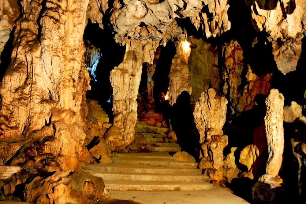 Stone steps lead to the cave’s entrance, unveiling a vast and majestic space